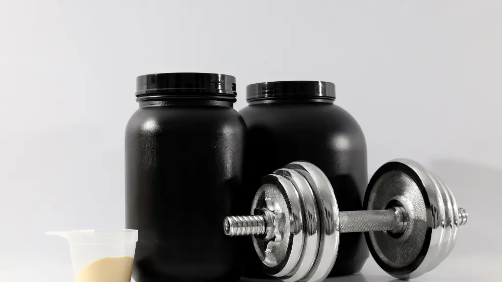 Potes de whey protein isolado ao lado de haltere e scoop de suplemento